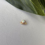 14K gold UFO opal flat back earring shown resting on a surface for true-to-life size reference