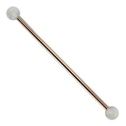 14k rose gold industrial barbell with white synthetic opal ball ends, front view